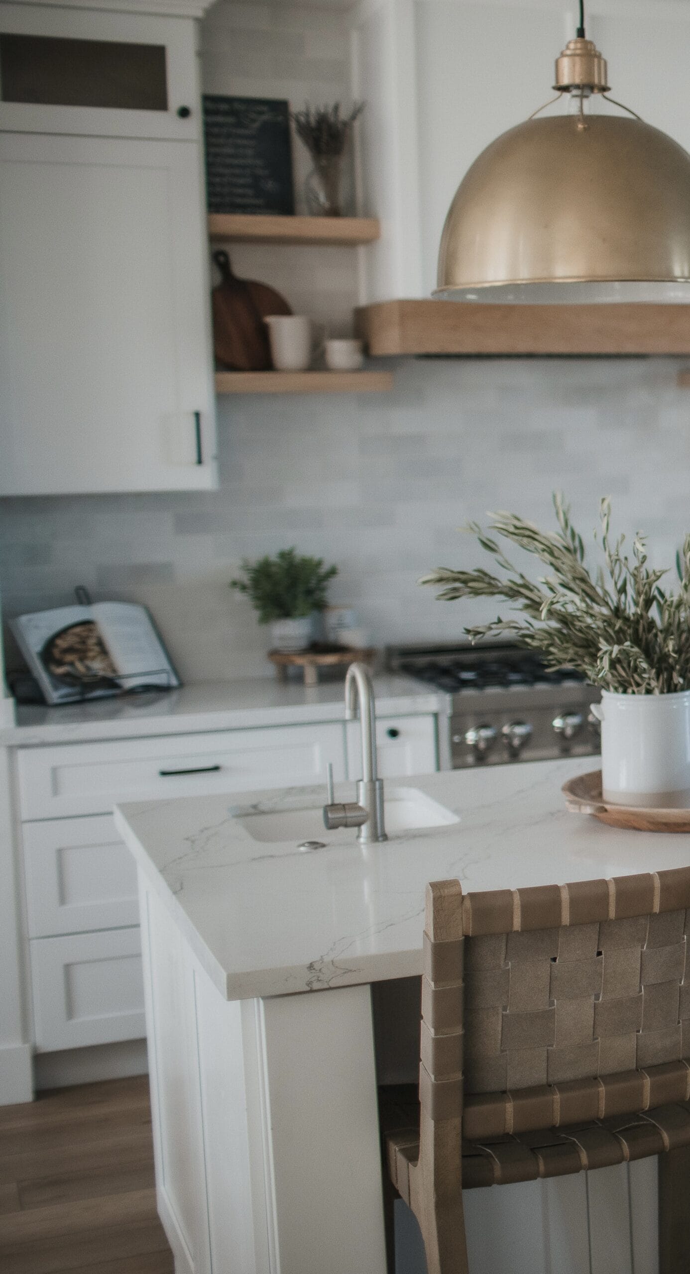 Elegant kitchen with contemporary design, featuring a marble island, pendant lighting, and organized.