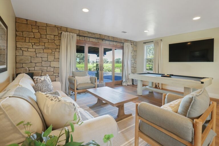 Spacious living room featuring a stone accent wall, large windows, and comfortable seating for relax.