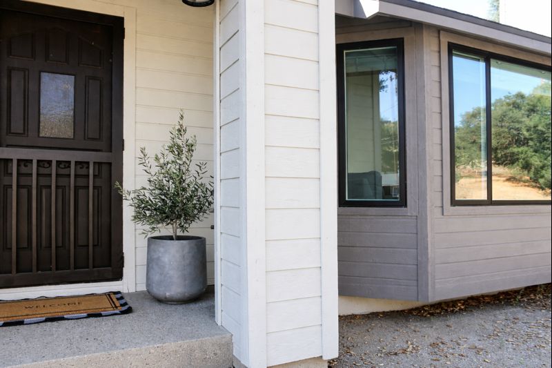 Front exterior of a modern home with updated siding, landscaping, and welcoming entryway